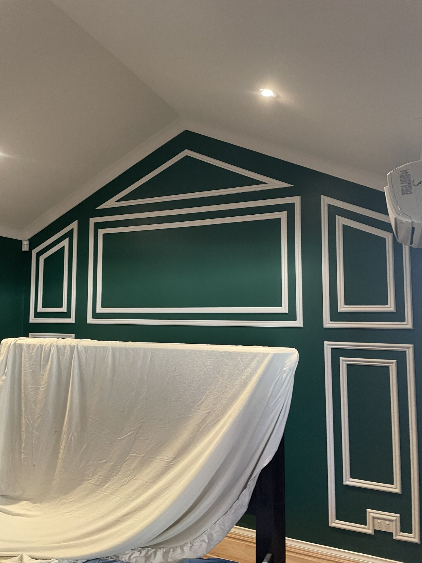 Emerald feature wall with detailed moulding, finished by Glint Plus Painting